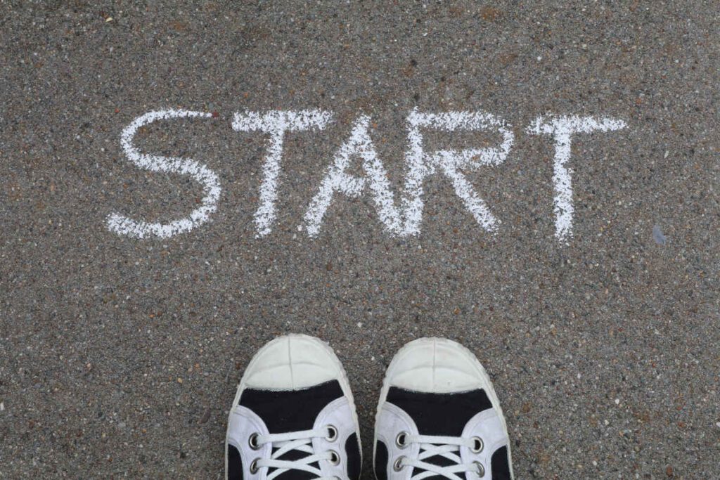 Looking from above onto a chalked word on the pavement, 'START'