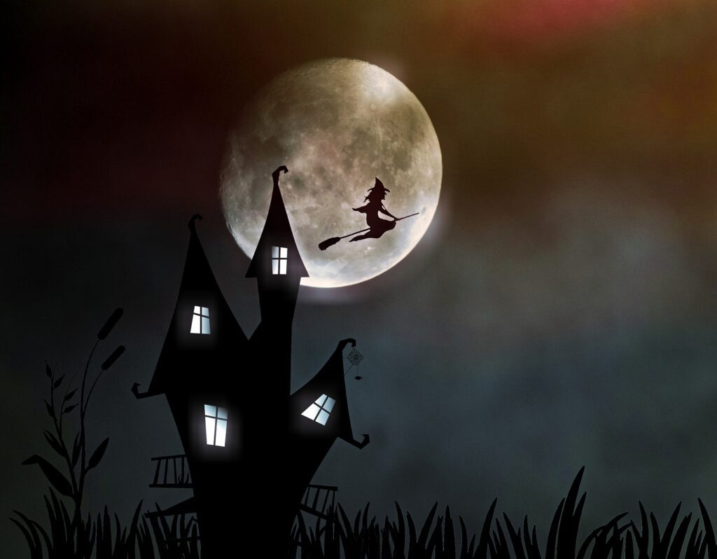 A fairytale silhouette of a witch on a broom flying from the castle backlit by the moon